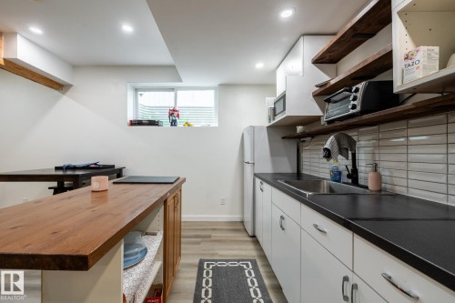 Kitchenette with white cabinetry, black countertops, and a stainless steel sink - 2036 Towne Centre Boulevard, Edmonton, AB - Indoor Photo Showing Kitchen
