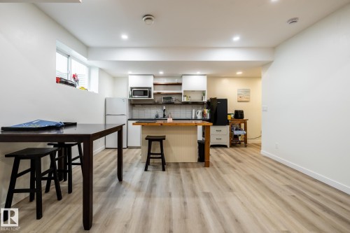 Open-concept kitchen and living area featuring wood-finish flooring, recessed lighting, and a kitchen island with a wooden countertop - 2036 Towne Centre Boulevard, Edmonton, AB - Indoor