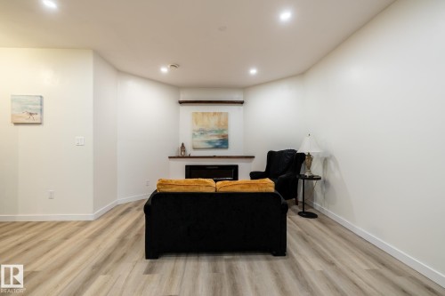 Living space featuring a built-in fireplace with a wooden mantel and shelf, recessed lighting, light wood-finish flooring, and crisp white walls - 2036 Towne Centre Boulevard, Edmonton, AB - Indoor