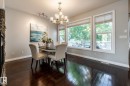 Dining area featuring dark wood-finish flooring, a stone-clad fireplace surround, a multi-pane window assembly, recessed lighting, and a decorative chandelier - 2036 Towne Centre Boulevard, Edmonton, AB  - Indoor Photo Showing Dining Room 
