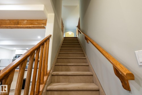 Carpeted staircase featuring a solid wood railing and banister - 2036 Towne Centre Boulevard, Edmonton, AB - Indoor Photo Showing Other Room