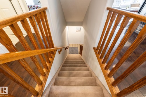 Carpeted staircase featuring solid wood railings and a light neutral wall color - 2036 Towne Centre Boulevard, Edmonton, AB - Indoor Photo Showing Other Room