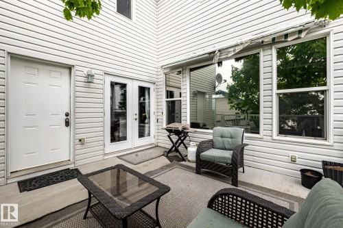 Private concrete patio featuring white vinyl siding, double-pane windows, and a dedicated exterior door - 2036 Towne Centre Boulevard, Edmonton, AB - Outdoor With Exterior