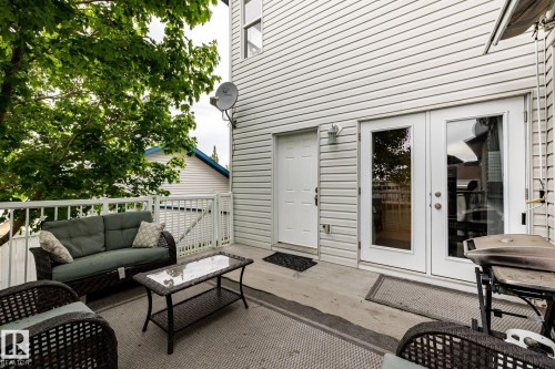 Exterior deck featuring white vinyl railing, concrete flooring, and mature tree coverage - 2036 Towne Centre Boulevard, Edmonton, AB - Outdoor With Exterior