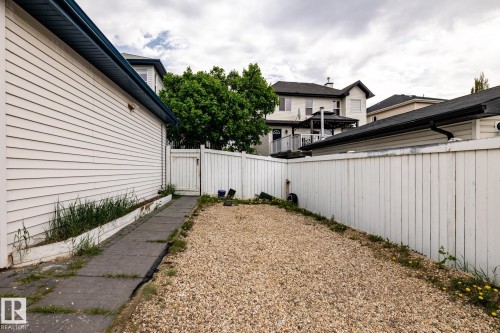Gravel patio area featuring a white privacy fence and a paved pathway alongside the structure - 2036 Towne Centre Boulevard, Edmonton, AB - Outdoor