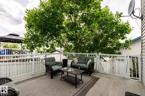 Spacious outdoor deck featuring a light gray outdoor area rug, white railing, mature tree canopy, and a visible gazebo structure - 2036 Towne Centre Boulevard, Edmonton, AB - Outdoor With Exterior
