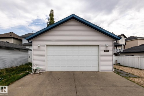 Detached garage featuring light-colored siding, a dark blue roofline, and an overhead garage door - 2036 Towne Centre Boulevard, Edmonton, AB - Outdoor With Exterior