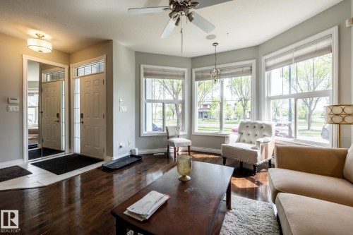 Living area featuring wood-finish flooring, a bay window configuration, and a ceiling fan with integrated lighting - 2036 Towne Centre Boulevard, Edmonton, AB - Indoor Photo Showing Living Room