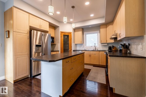 Kitchen featuring light wood-finish cabinetry, dark countertops, and stainless steel appliances - 2036 Towne Centre Boulevard, Edmonton, AB - Indoor Photo Showing Kitchen