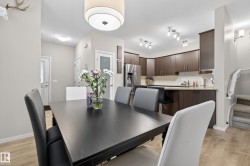 Dining area with wood-finish flooring and a contemporary drum pendant light fixture - 