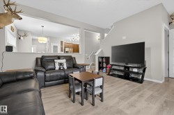 Open-concept living area featuring light wood-finish flooring and neutral wall tones - 