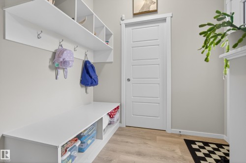 Built-in mudroom organization system featuring upper cubbies, lower open shelving, and coat hooks - 70 James Crescent, St. Albert, AB 