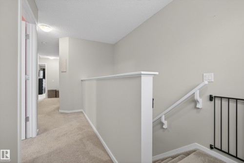 Carpeted landing with white railing and neutral wall tones - 70 James Crescent, St. Albert, AB 