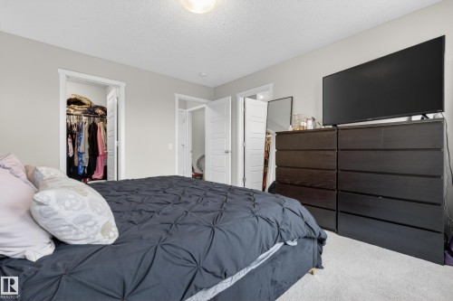 Bedroom featuring light gray walls, white trim, and a built-in closet with an open doorway - 70 James Crescent, St. Albert, AB 