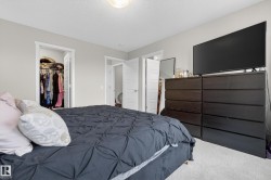 Bedroom featuring light gray walls, white trim, and a built-in closet with an open doorway - 