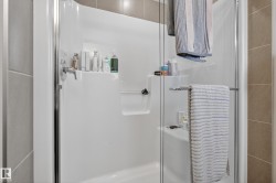 Enclosed shower with a chrome single-handle faucet, integrated shelving, and a built-in bench - 