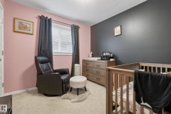 Carpeted room featuring a window with blinds and dark curtains, a two-tone wall design with pink and dark gray paint, and a white interior door - 
