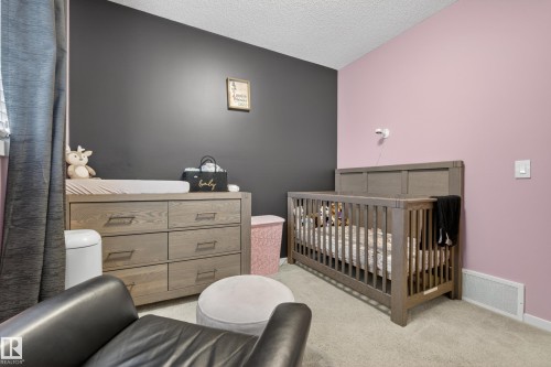 Room featuring two-tone wall paint, a built-in air vent, and carpet flooring - 70 James Crescent, St. Albert, AB 