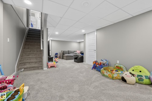 Finished basement featuring plush gray carpeting, recessed lighting, and a drop ceiling - 70 James Crescent, St. Albert, AB 