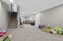 Finished basement featuring plush gray carpeting, recessed lighting, and a drop ceiling - 