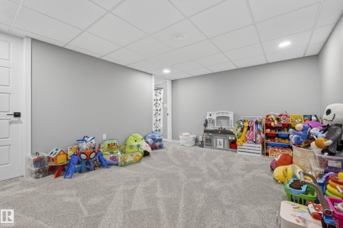 Spacious room featuring light gray carpet, recessed lighting, and a white acoustical tile ceiling - 70 James Crescent, St. Albert, AB 