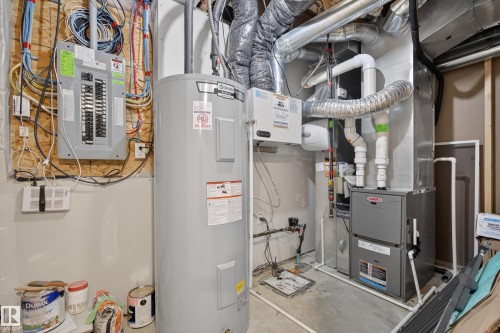 Utility area featuring a water heater, furnace system, ductwork, and an electrical panel - 70 James Crescent, St. Albert, AB 