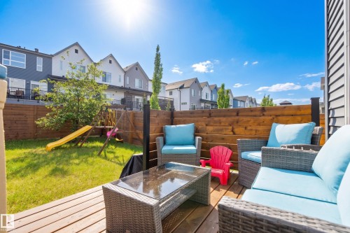 Spacious outdoor deck with natural wood planks, a solid wood privacy fence, and a green lawn area - 70 James Crescent, St. Albert, AB 