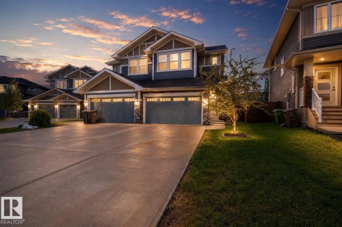 Craftsman-style exterior featuring a multi-gable roofline, board and batten siding, stone accents, and a concrete driveway - 70 James Crescent, St. Albert, AB 