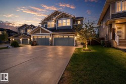 Craftsman-style exterior featuring a multi-gable roofline, board and batten siding, stone accents, and a concrete driveway - 