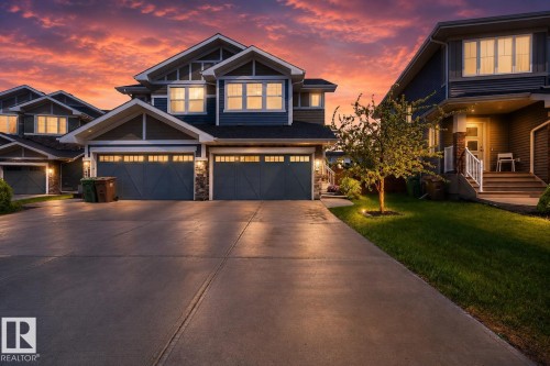 Contemporary two-story exterior with blue siding and stone accents - 70 James Crescent, St. Albert, AB 