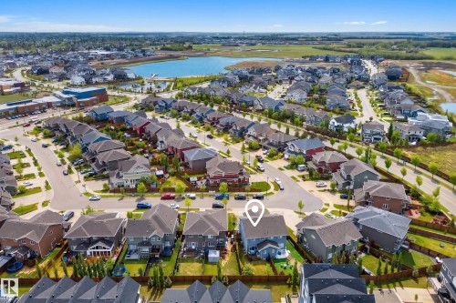 Aerial perspective of a residential neighborhood featuring a central lake and surrounding green spaces - 70 James Crescent, St. Albert, AB 