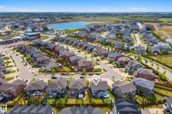 Aerial perspective of a residential neighborhood featuring a central lake and surrounding green spaces - 