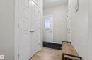 Entryway featuring light wood-finish flooring, white paneled doors, and a front door with a window insert - 70 James Crescent, St. Albert, AB 