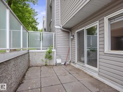 Patio area featuring square pavers and textured stucco wall - 