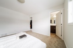 Carpeted interior space featuring white painted walls and trim, with a ceiling-mounted light fixture - 