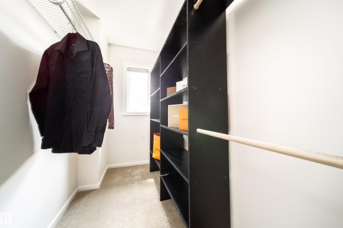 Walk-in closet featuring carpet flooring and white walls - 405 Simmonds Way, Leduc, AB 
