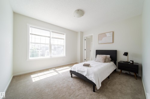 Spacious room with light-toned wall paint and neutral carpeting - 405 Simmonds Way, Leduc, AB 