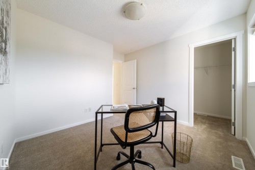Room featuring neutral wall paint, light-colored carpeting, a ceiling-mounted light fixture, and a window providing natural illumination - 405 Simmonds Way, Leduc, AB 