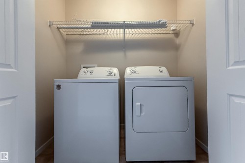 Dedicated laundry closet featuring a top-load washer, front-load dryer, and an overhead wire storage shelf - 405 Simmonds Way, Leduc, AB 