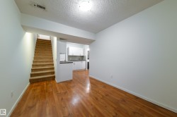 Open-concept living area with wood-finish flooring extending into the kitchen - 