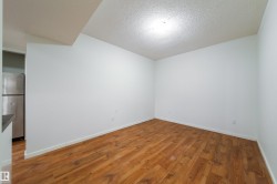 Open concept living space featuring wood-finish flooring, white baseboards, and a neutral color palette - 