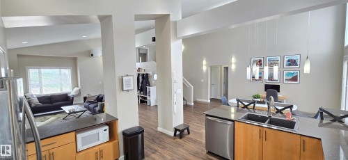 Open concept interior featuring high vaulted ceilings, wood-finish flooring, recessed lighting, and a kitchen island with an undermount sink - 4234 46 Street, Vegreville, AB - Indoor Photo Showing Other Room