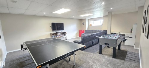 Spacious recreation room featuring recessed lighting, a drop ceiling, and carpeted flooring - 4234 46 Street, Vegreville, AB - Indoor