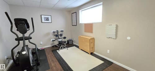 Flexible room featuring wood-finish flooring, neutral wall tones, and a drop ceiling - 4234 46 Street, Vegreville, AB - Indoor