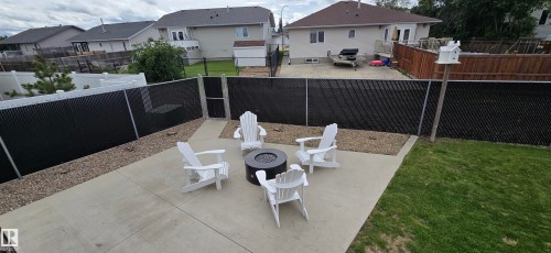 Expansive concrete patio area featuring a central fire pit - 4234 46 Street, Vegreville, AB - Outdoor
