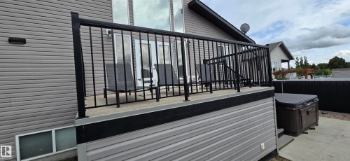 Raised deck with black aluminum railing and concrete surface - 4234 46 Street, Vegreville, AB - Outdoor With Deck Patio Veranda With Exterior