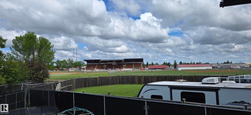 Expansive outdoor space featuring a dark wood fence and a green lawn - 4234 46 Street, Vegreville, AB - Outdoor