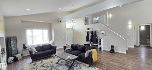 Vaulted ceilings enhance this living space featuring wood-finish flooring and a built-in window seat - 4234 46 Street, Vegreville, AB - Indoor Photo Showing Living Room