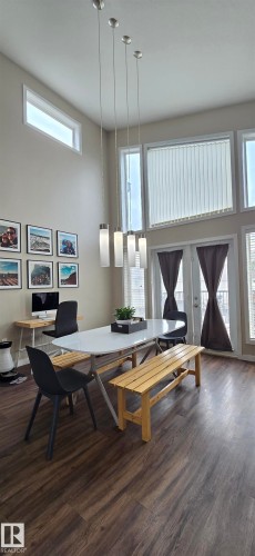 High ceilings with a modern chandelier, wood-finish flooring, and a bank of tall windows - 4234 46 Street, Vegreville, AB - Indoor