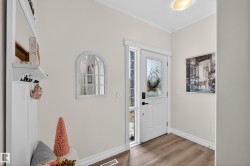 Entryway with wood-finish flooring, white baseboards, and neutral wall paint - 